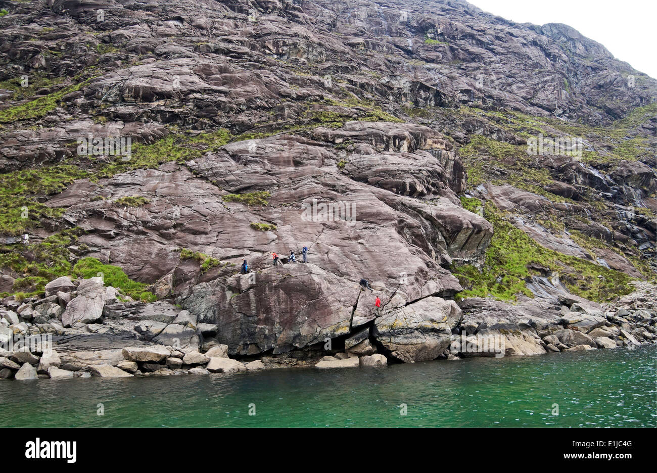 Groupe de marcheurs passant sur la mauvaise étape à Loch Scavaig Île de Skye Highland Ecosse Banque D'Images