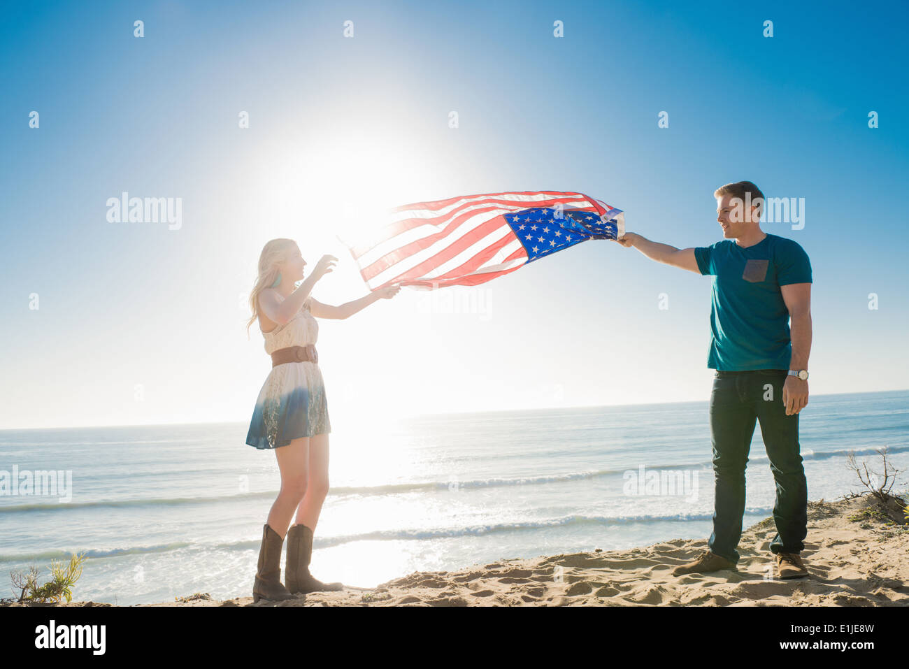 Jeune couple à l'autre holding up drapeau américain, Torrey Pines, San Diego, California, USA Banque D'Images