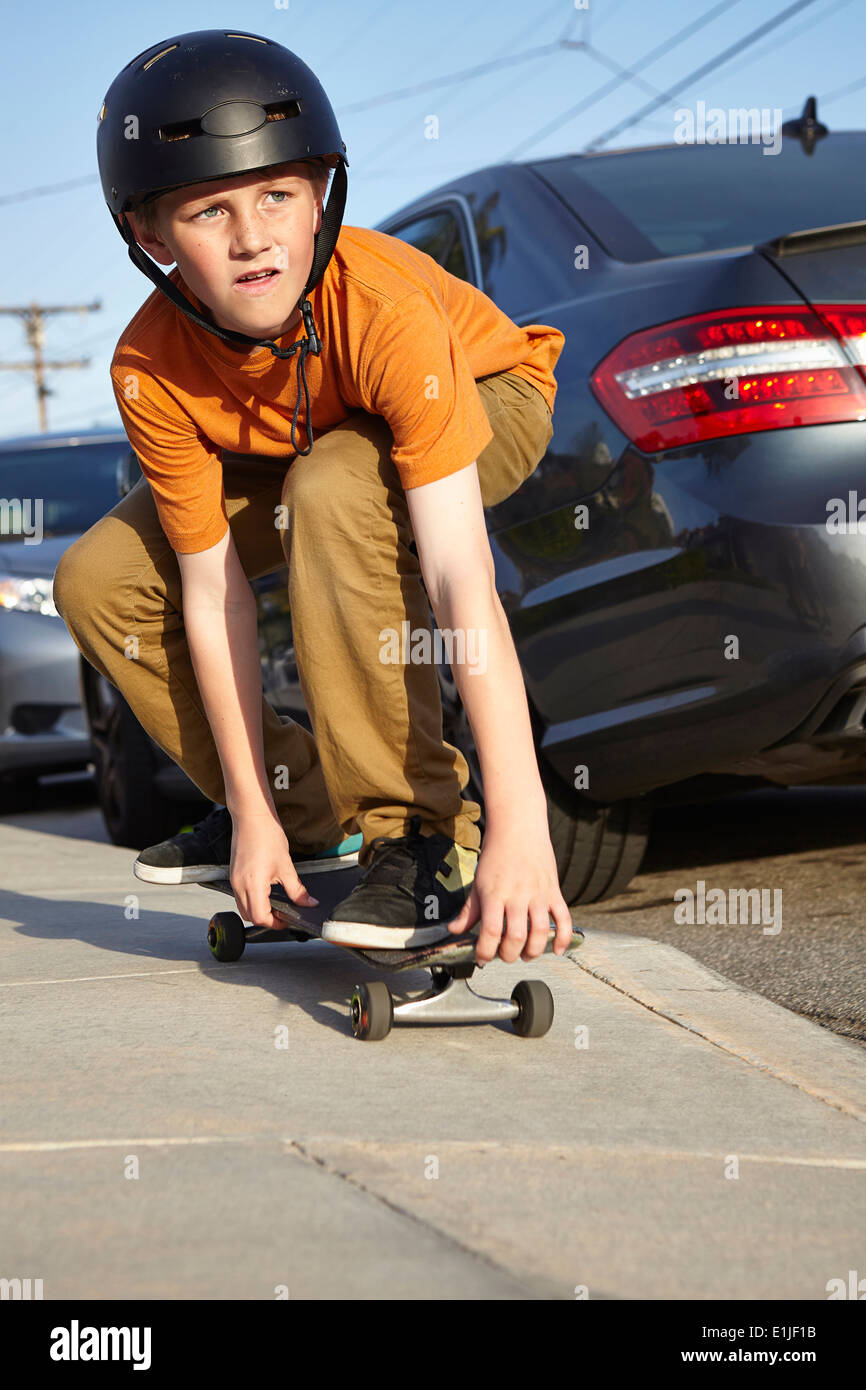 Boy skateboarding sur la chaussée Banque D'Images