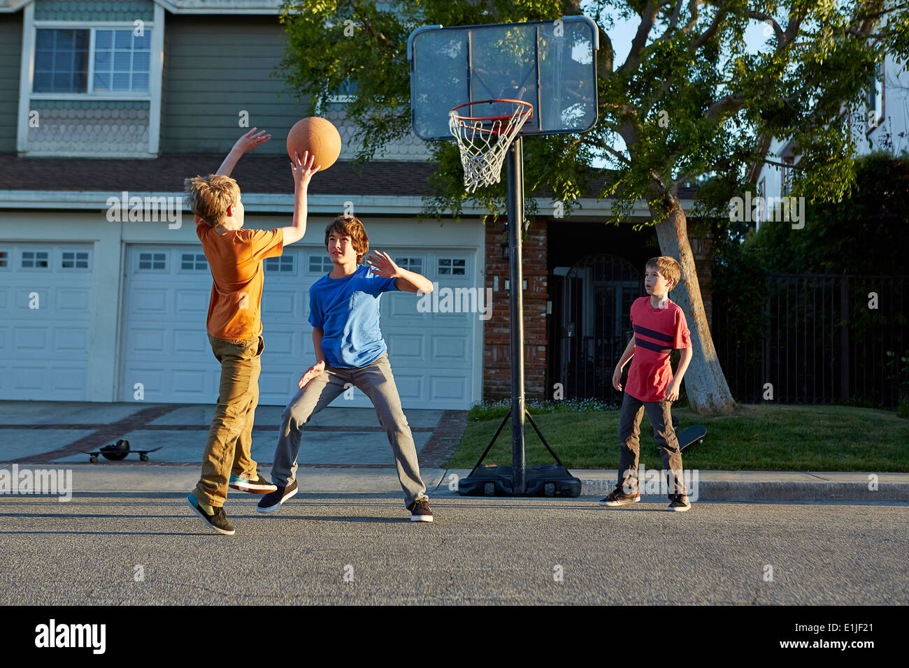 Garçons jouant au basket-ball à l'extérieur chambre Banque D'Images