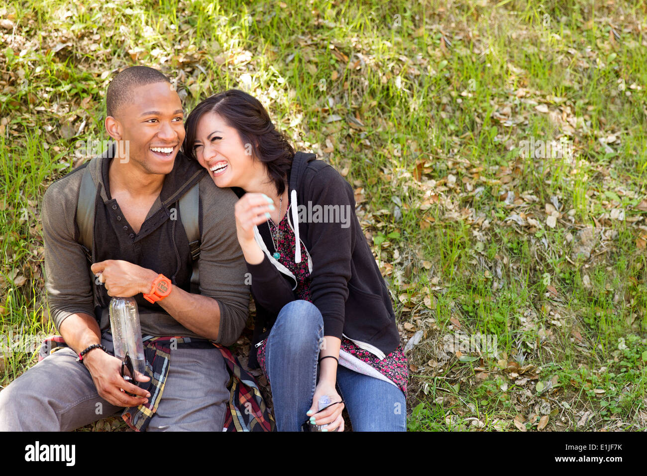 Jeune couple assis sur l'herbe du parc Banque D'Images