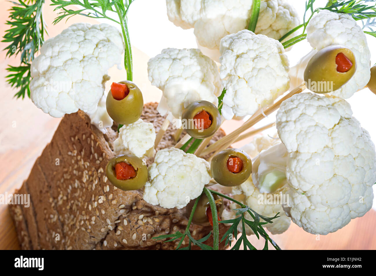 Un bouquet d'olives et le chou-fleur dans un panier à pain avec une faible profondeur de champ. Banque D'Images