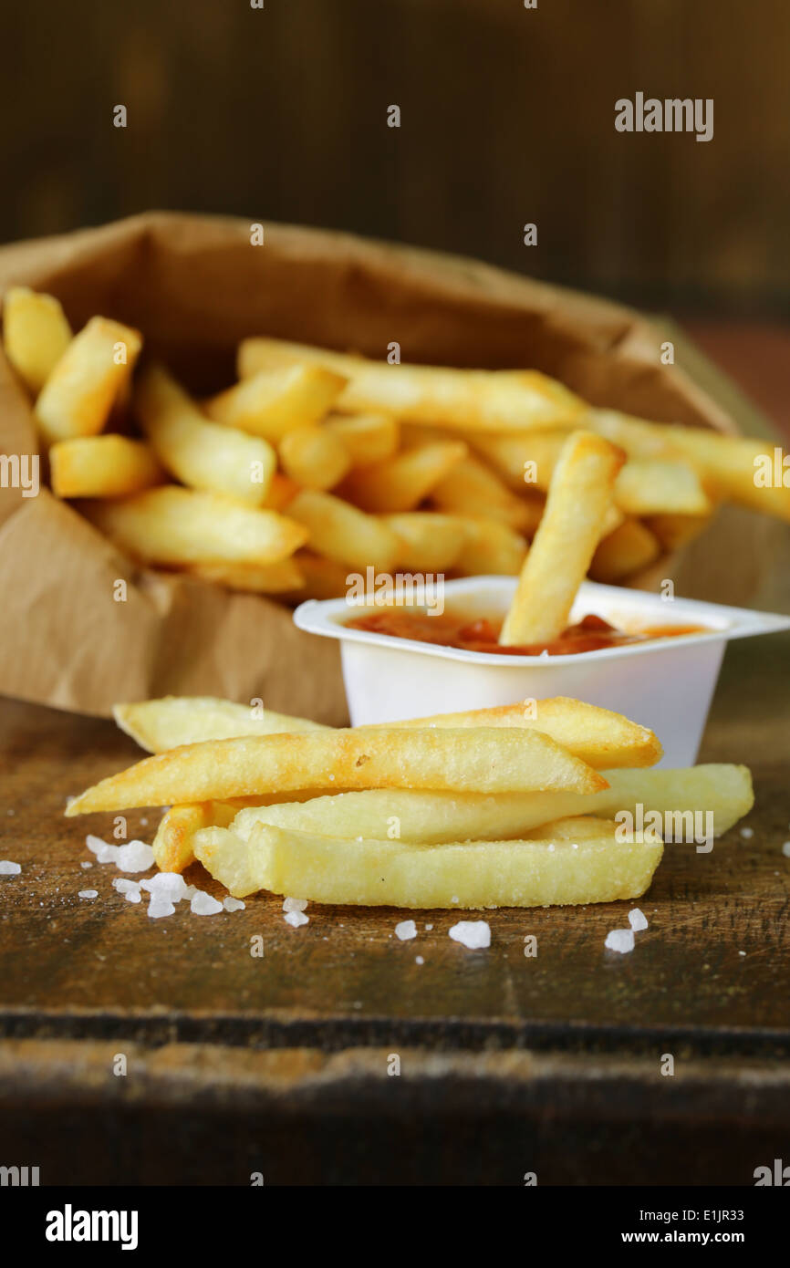 Pommes frites traditionnelles avec du sel sur fond de bois Banque D'Images