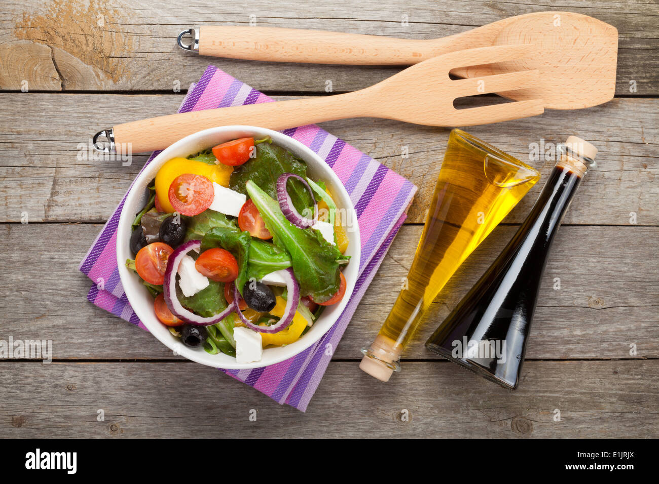 Salade fraîche healty sur table en bois avec l'huile d'olive, vinaigre et ustensile de cuisine. Vue de dessus Banque D'Images