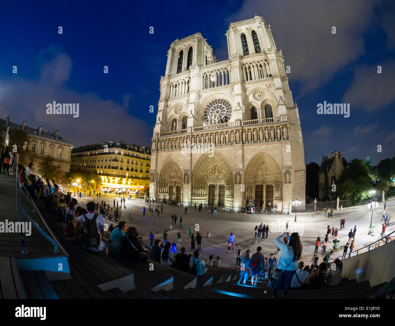 Les touristes visiter la cathédrale Notre Dame à Paris tard dans la soirée. Banque D'Images