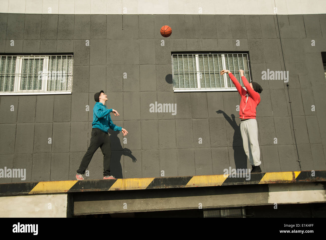 Adolescent et jeune homme jouant au basket-ball Banque D'Images