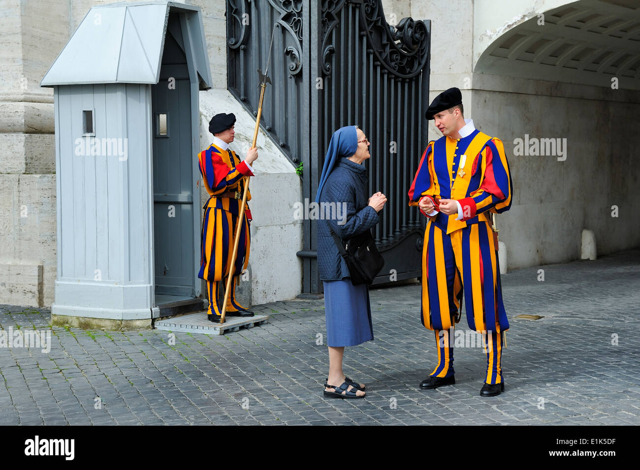Garde Suisse pontificale de parler avec une femme en face de la porte du Vatican Banque D'Images