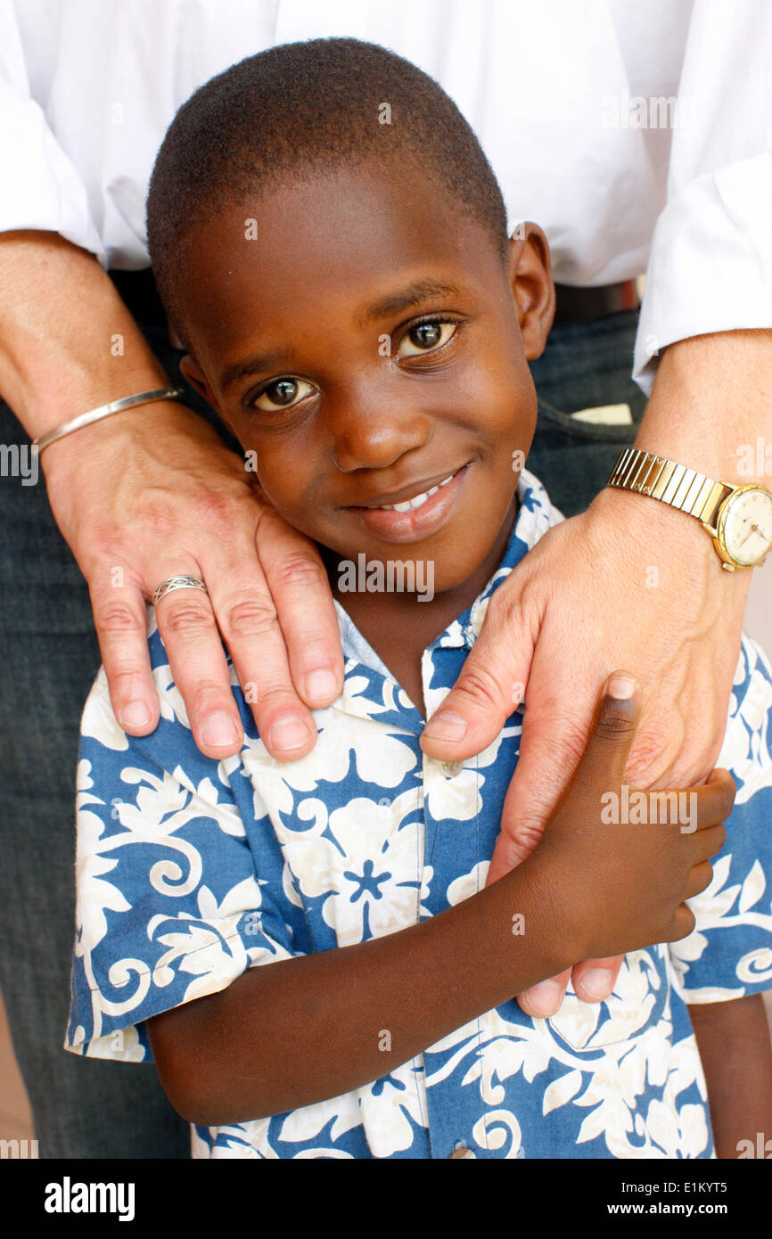 Enfant haïtien tenant une main blanche Banque D'Images