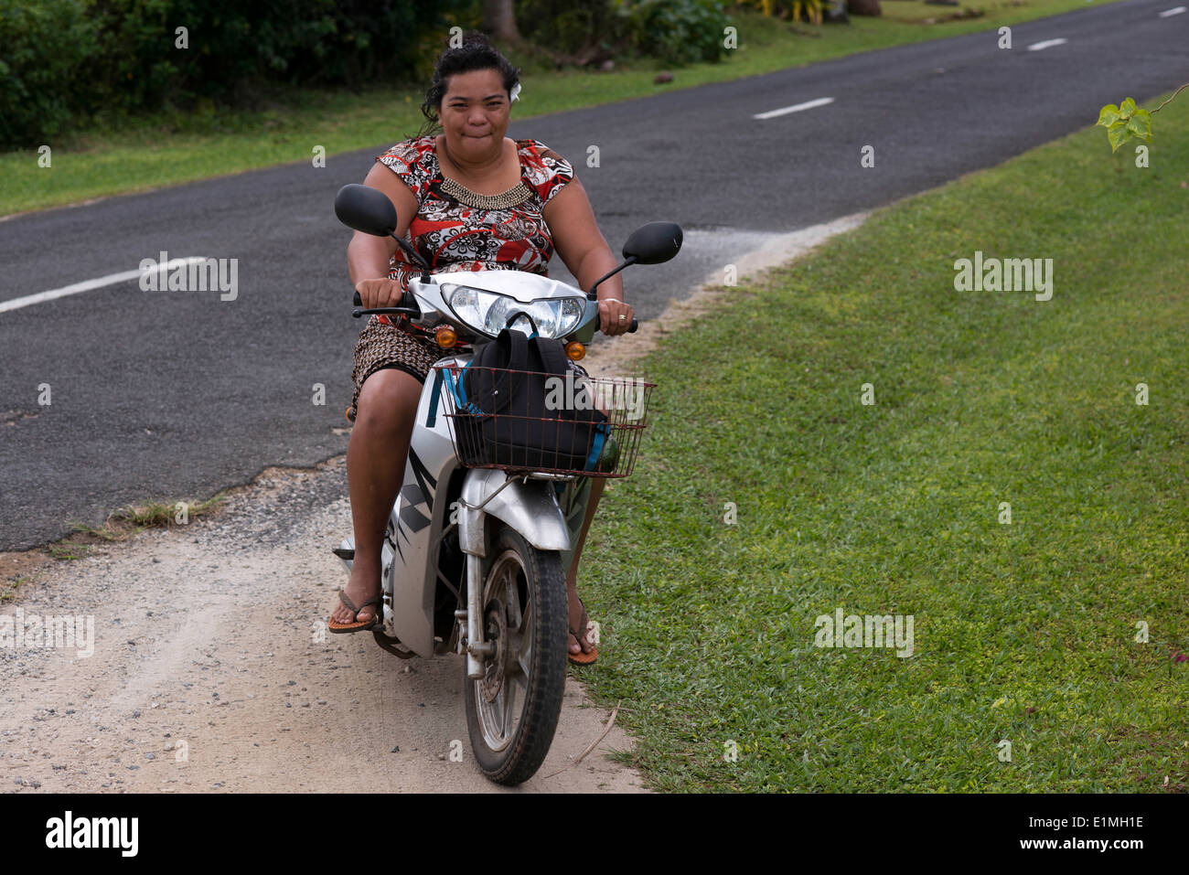 L'île de Rarotonga. L'île de Cook. Polynésie française. Océan Pacifique Sud. Deux personnes obèses conduire une motocyclette sur une route sur l'île Banque D'Images