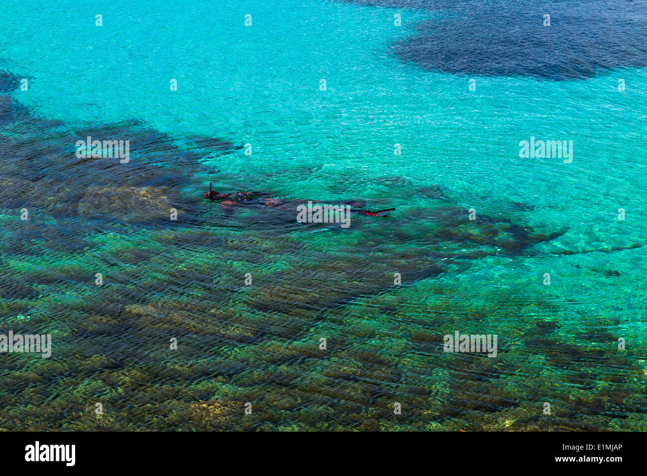 Un homme dans une combinaison de camouflage est vu la pêche au harpon dans l'eau claire de l'île de vis en Croatie Dalmatie Banque D'Images