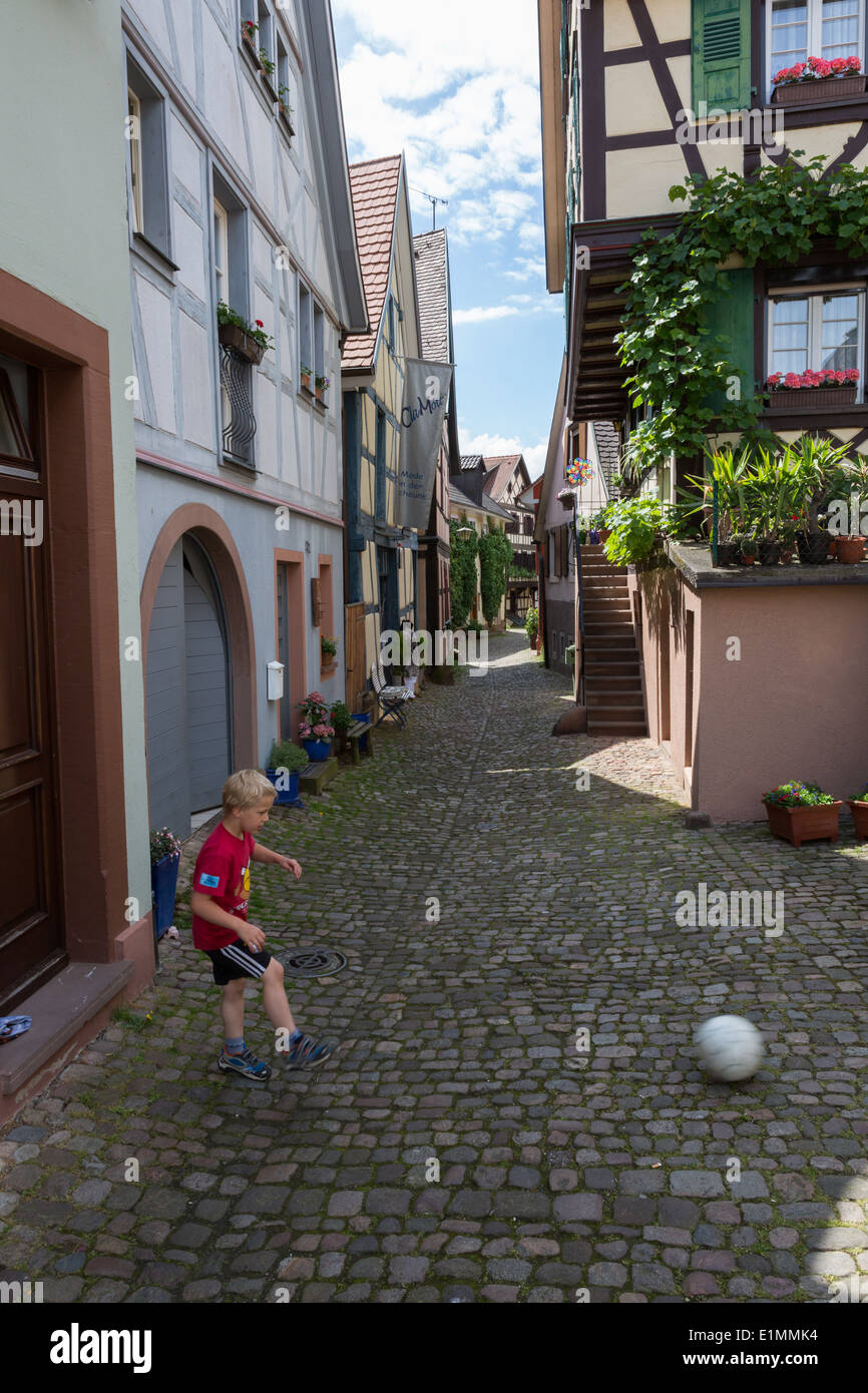 Un coup d'un garçon dans une ruelle de football-façon Forêt Noire ville de Gengenbach Banque D'Images