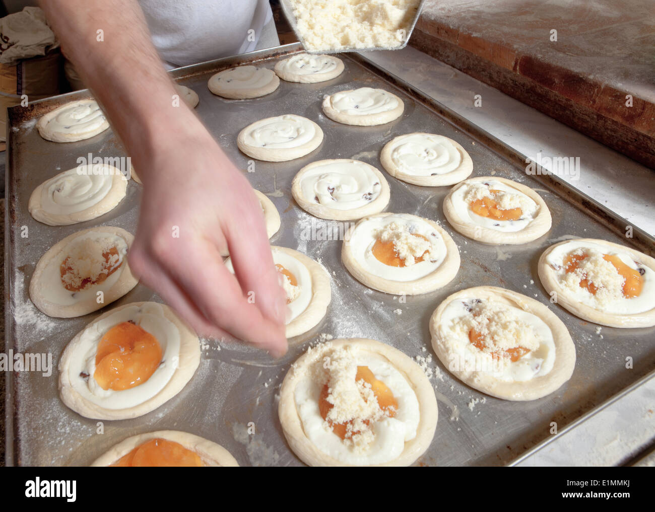 Boulangerie - L'ajout de professionnels du fromage sur le dessus de la pâte avant cuisson Banque D'Images