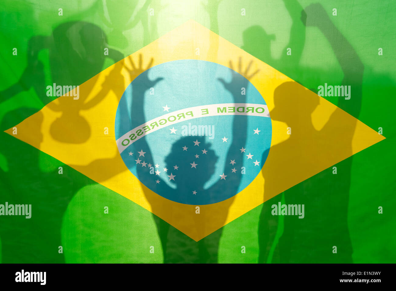 Joueurs de football drapeau brésilien des silhouettes d'ombre célébrant holding trophy gagnante contre le soleil Banque D'Images