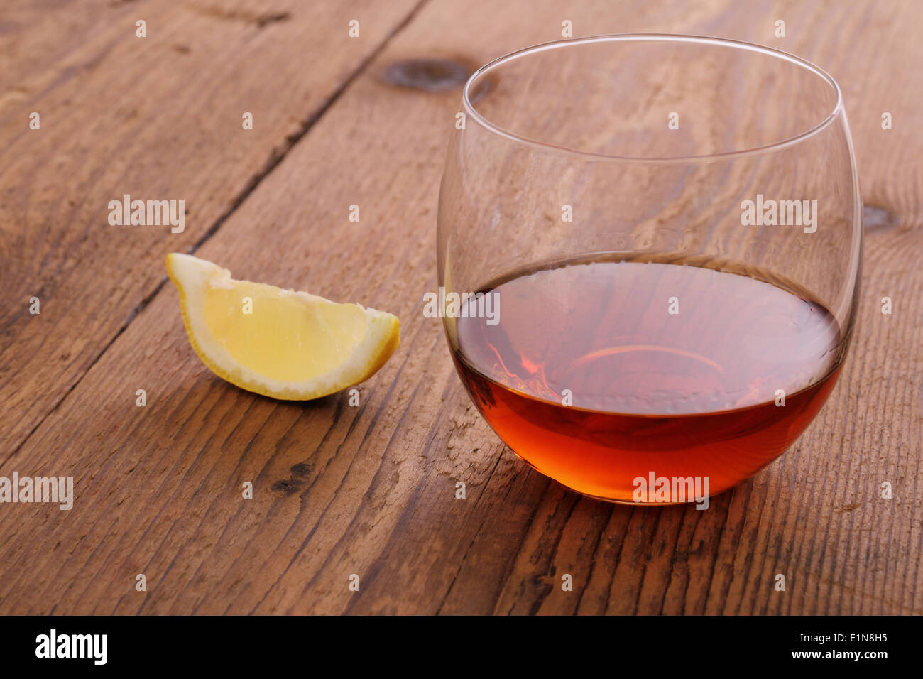 Cognac de luxe en verre décoratif sur bois avec du citron Banque D'Images