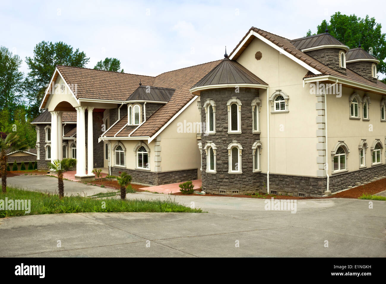 Photo horizontale de toute nouvelle maison construite sur mesure avec des palmiers à l'avant et large sur l'avant avec des arbres d'entraînement et en partie ciel bleu Banque D'Images