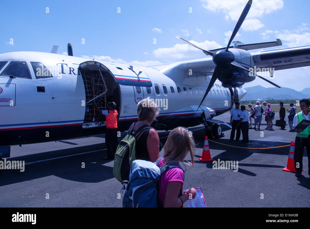 Un avion à hélices et les touristes à l'aéroport de Lombok, Indonésie Banque D'Images