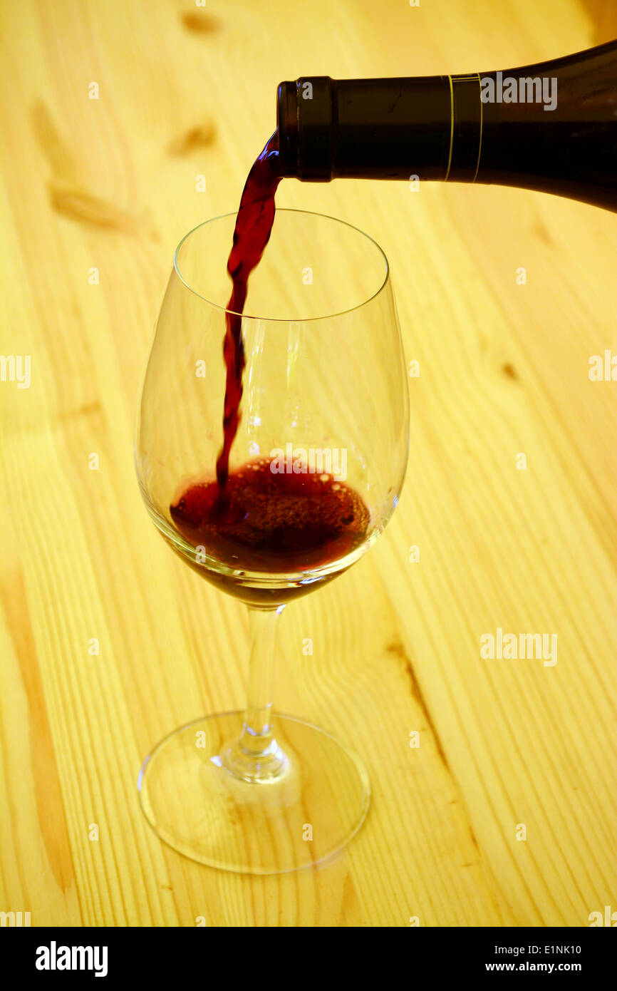 Verser le vin rouge dans un verre Banque D'Images