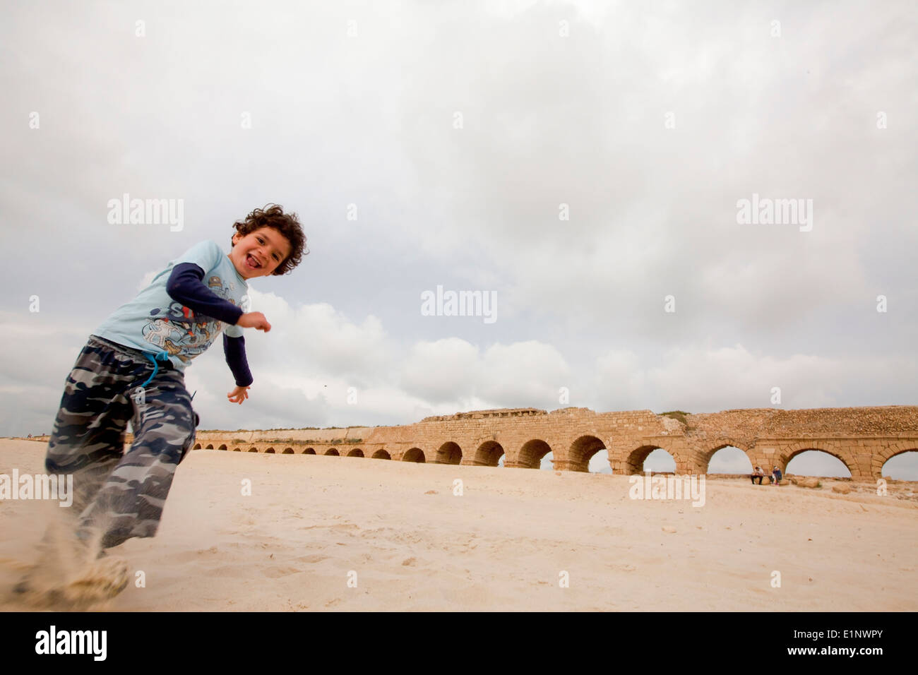 Enfant joue dans le sable l'Aqueduc Romain à l'arrière-plan Banque D'Images
