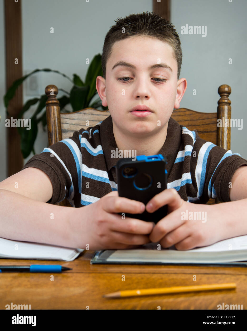 Un jeune adolescent utilise un smartphone ne fait son travail. Banque D'Images