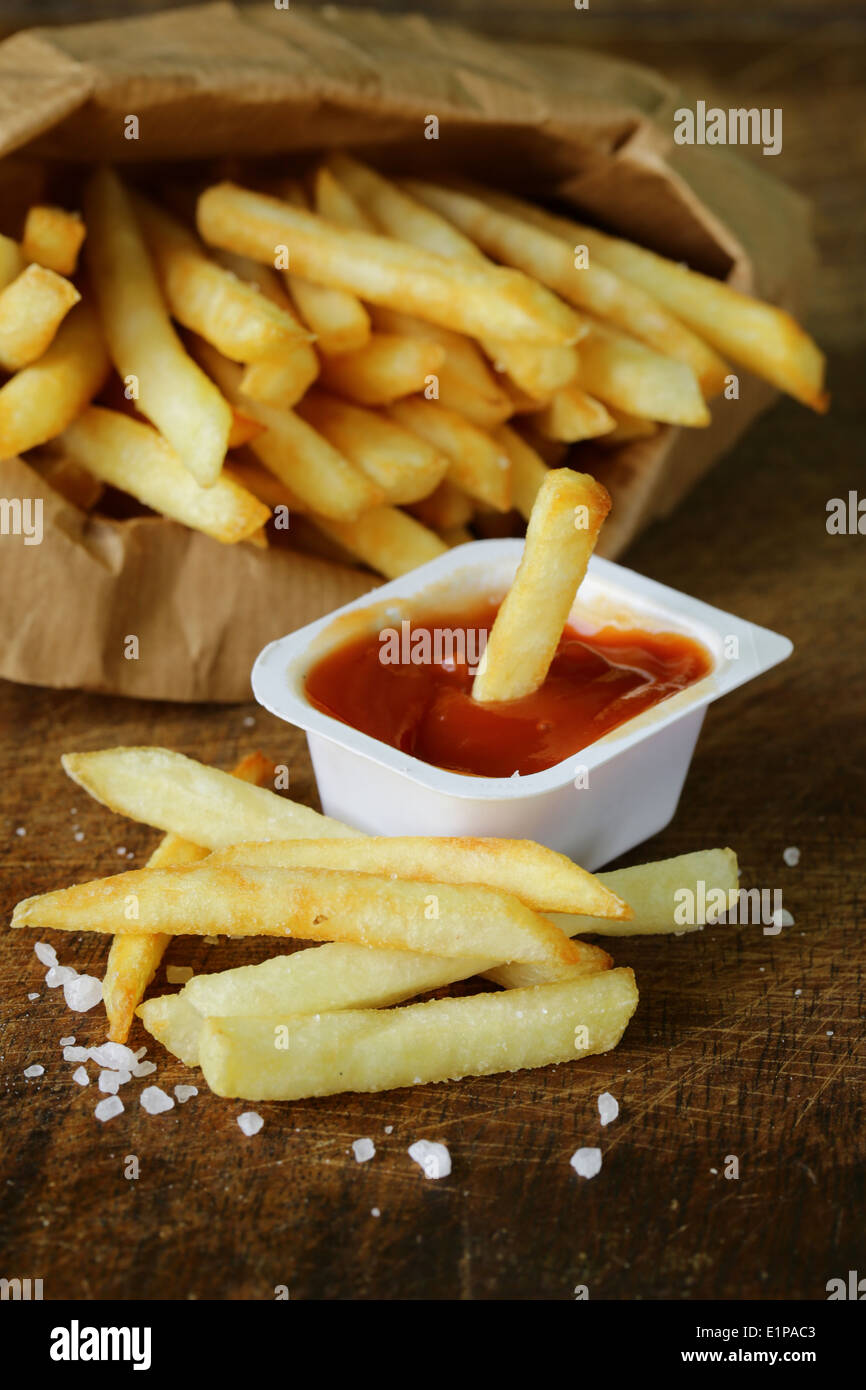 Pommes frites traditionnelles avec du sel sur fond de bois Banque D'Images