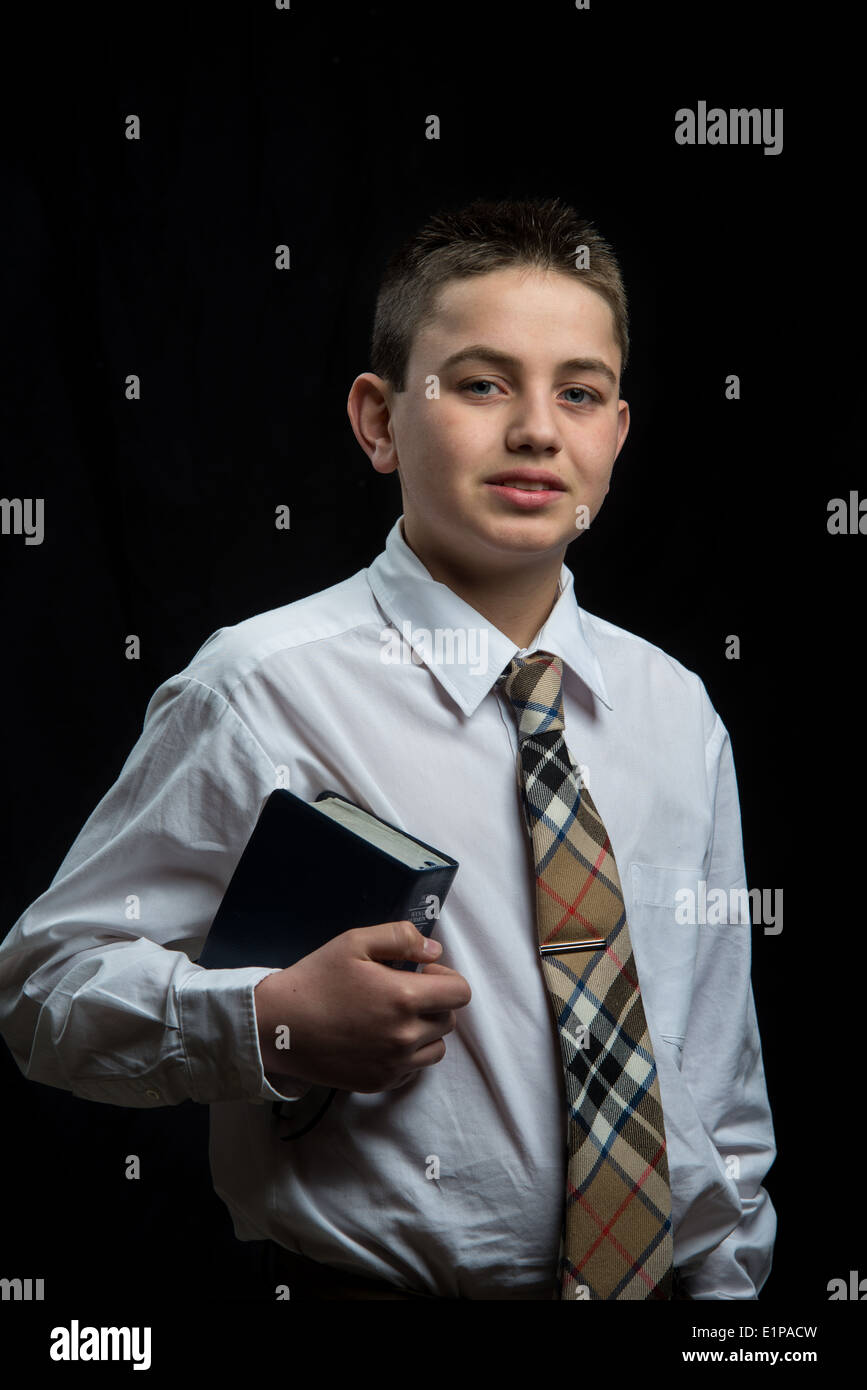 Un adolescent transportant écritures allant à l'église. Banque D'Images