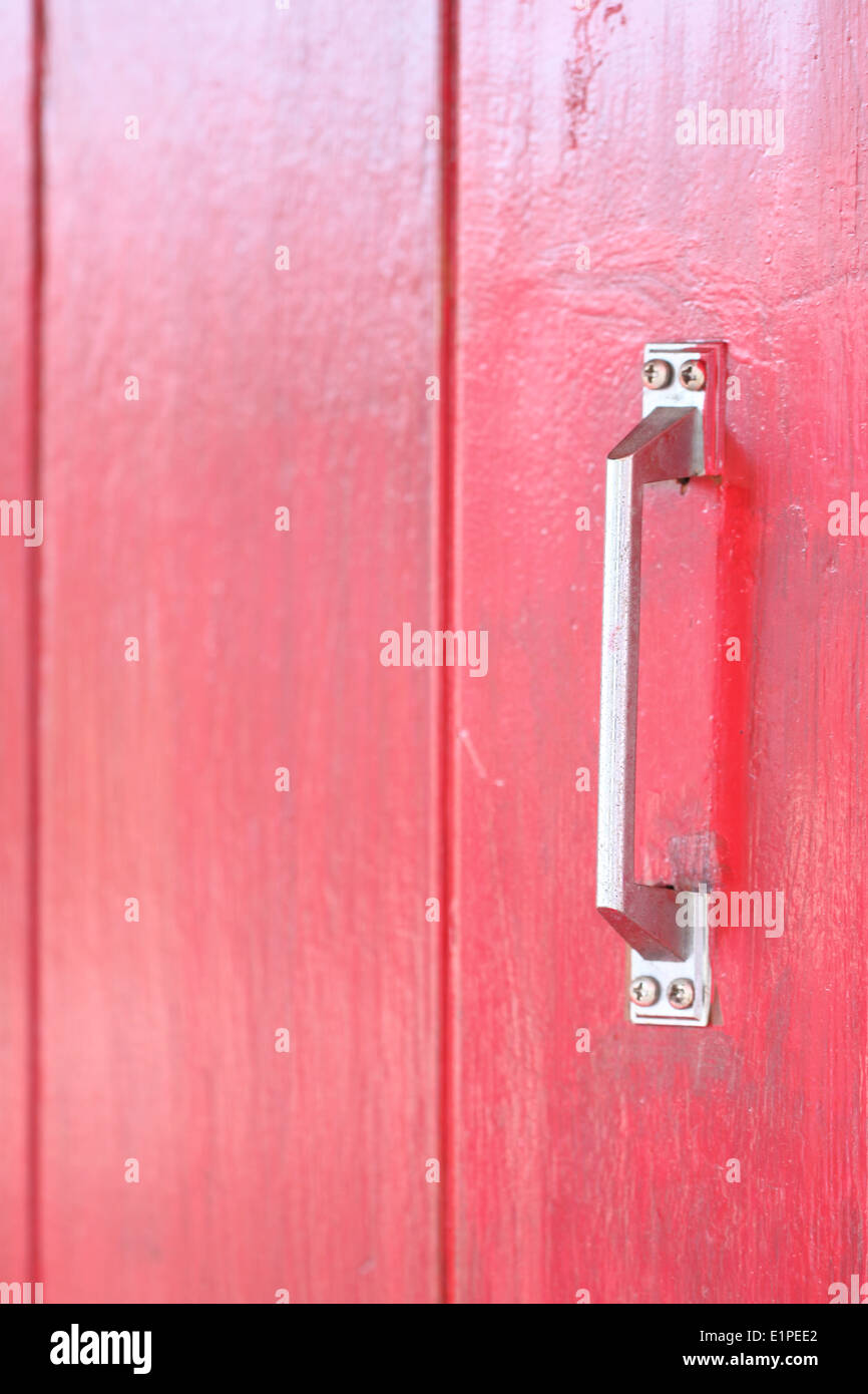 La texture du bois rouge et poignée porte à l'arrière-plan. Banque D'Images