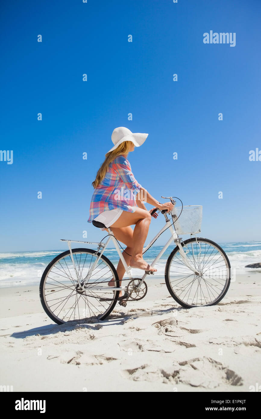 Jolie blonde sur un vélo à la plage Banque D'Images