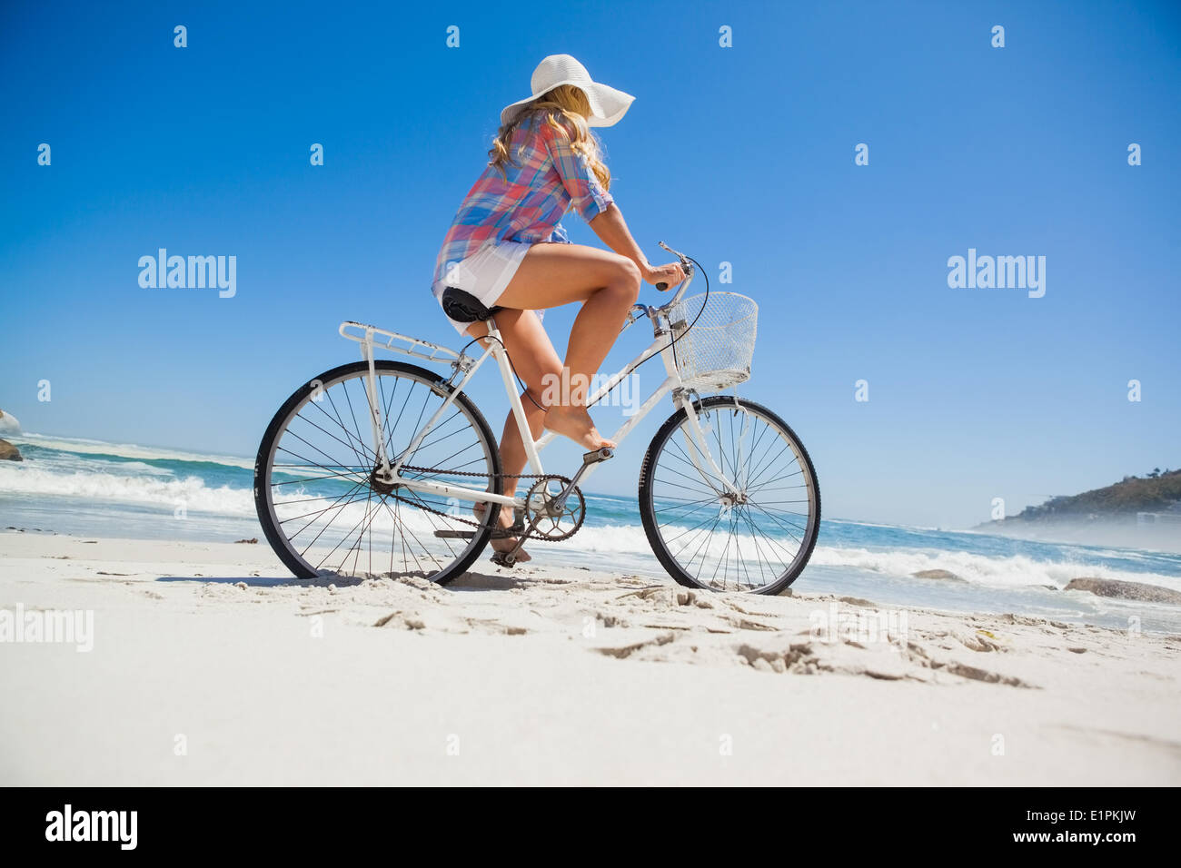 Jolie blonde sur un vélo à la plage Banque D'Images