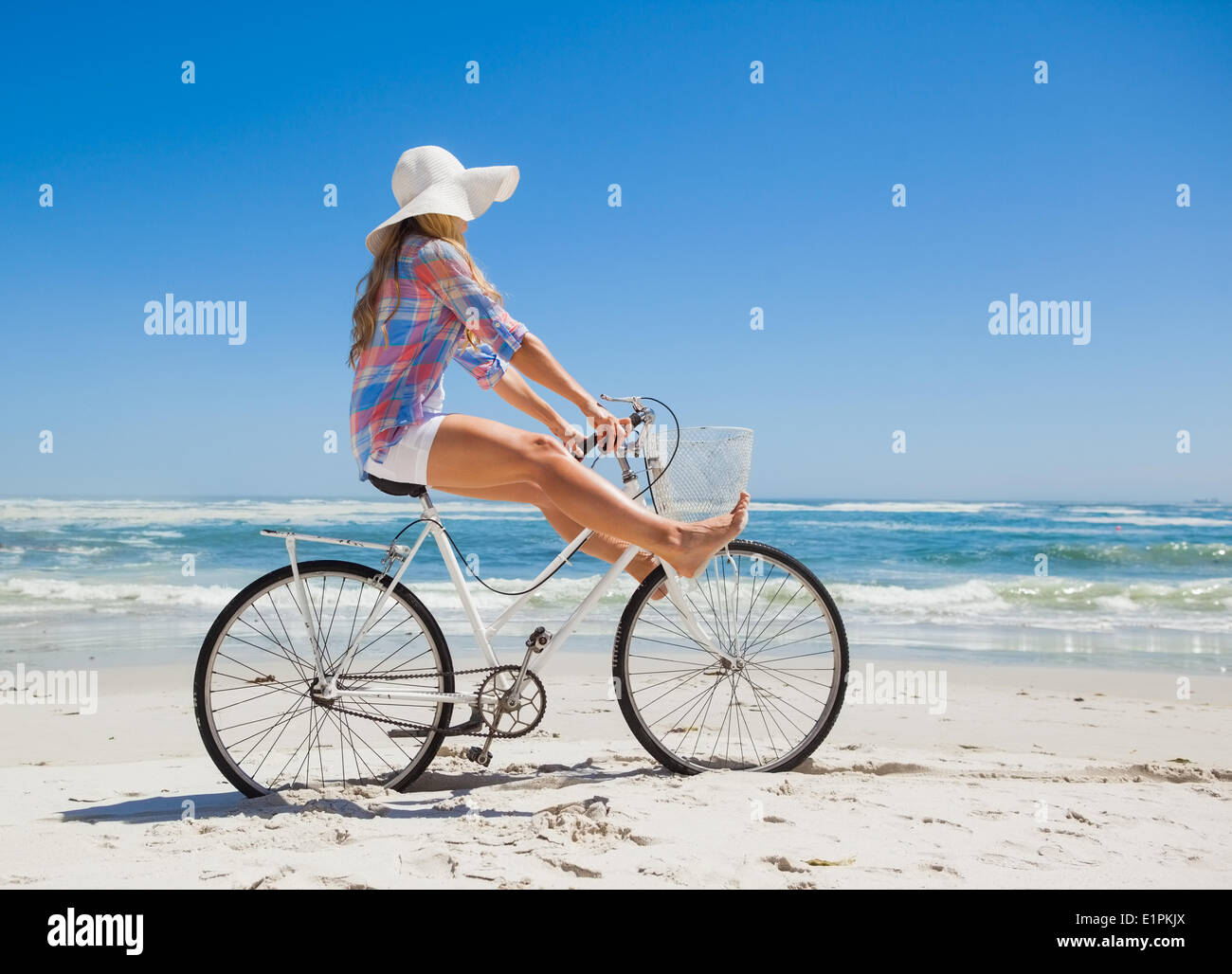 Jolie blonde sans souci sur une promenade en vélo à la plage Banque D'Images