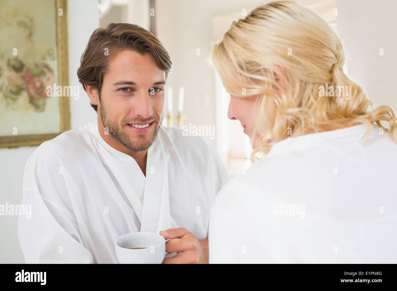 Cute couple en peignoirs having coffee together Banque D'Images