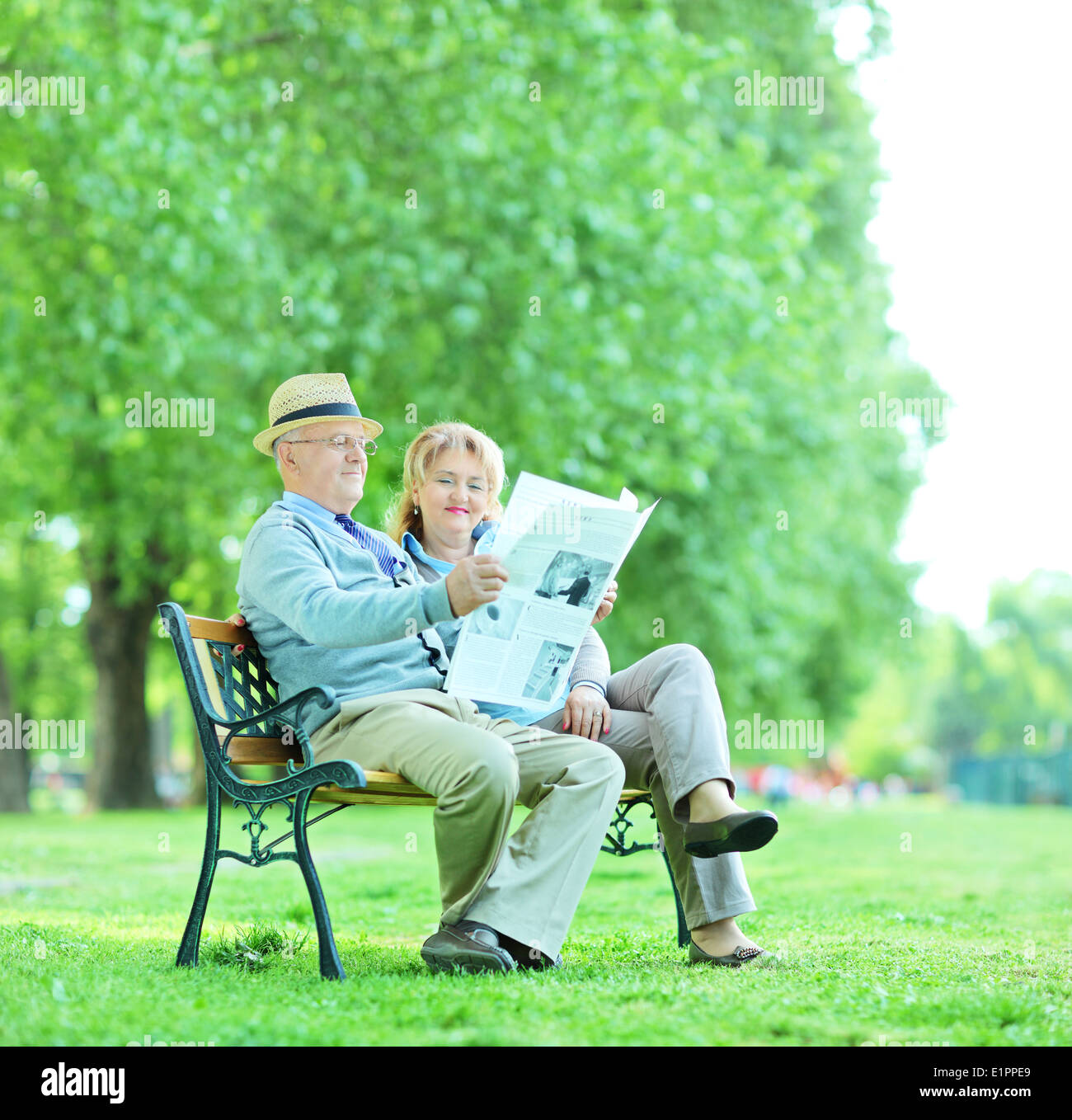 Homme et femme mature la lecture de l'actualité à l'extérieur Banque D'Images