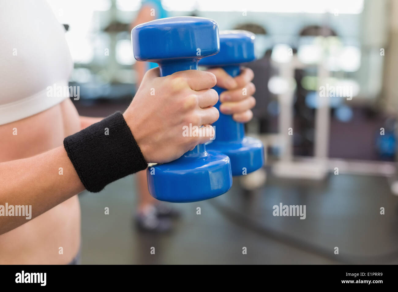 Fit woman exercising with dumbbells bleu Banque D'Images