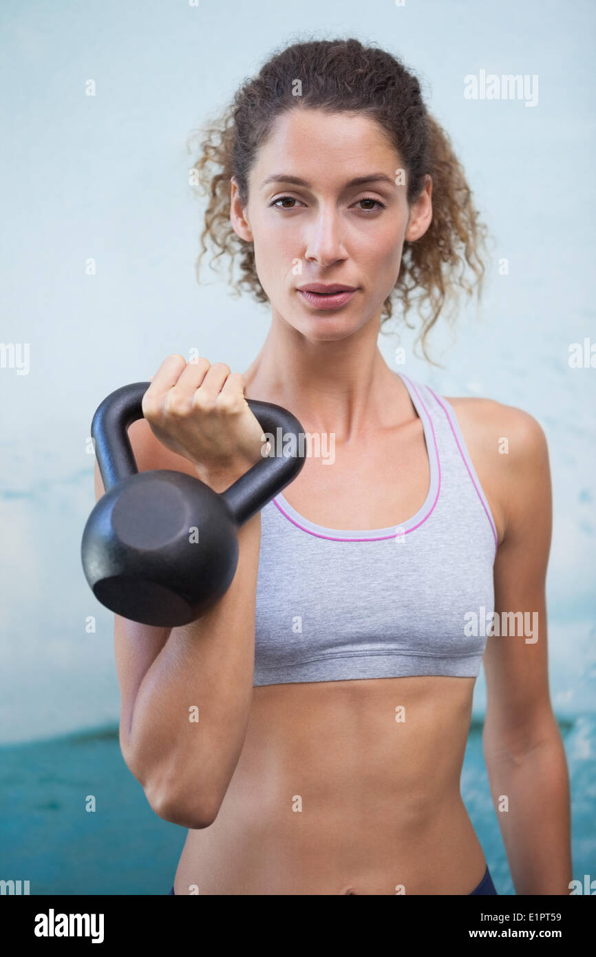 Fit woman looking at camera holding kettlebell Banque D'Images