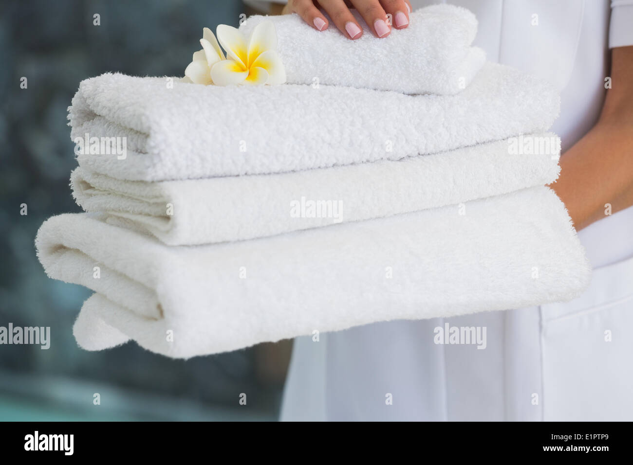 Esthéticien holding pile de serviettes blanches fraîches Banque D'Images