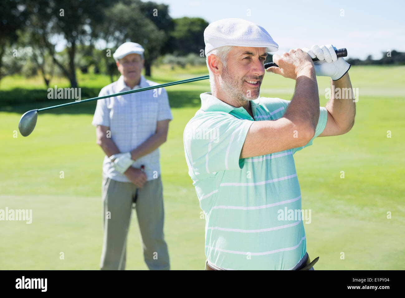 Son golfeur club avec ami derrière lui Banque D'Images