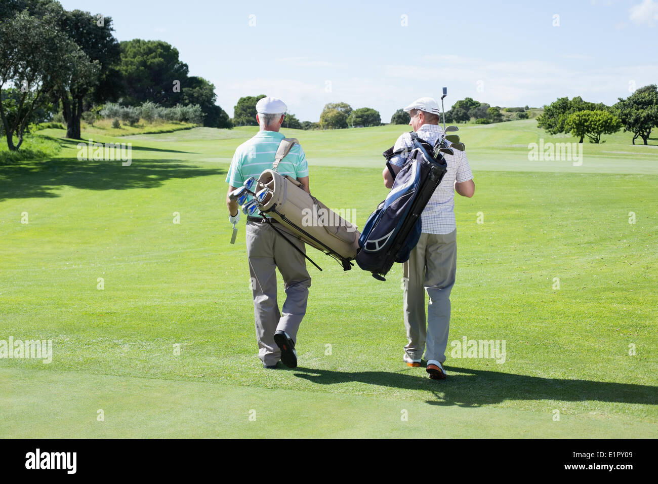 Balades amis golfeur tenant leurs sacs de golf Banque D'Images