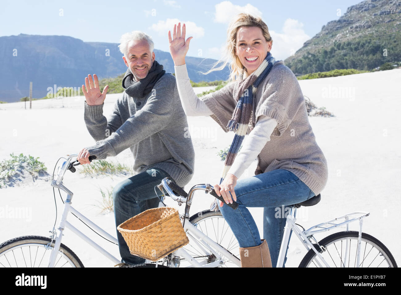 Carefree couple partir en promenade en vélo sur la plage forme at camera Banque D'Images
