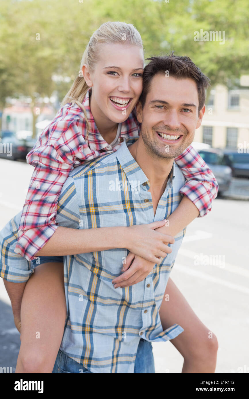 Jeune homme de la hanche donnant sa copine blonde un piggy back Banque D'Images