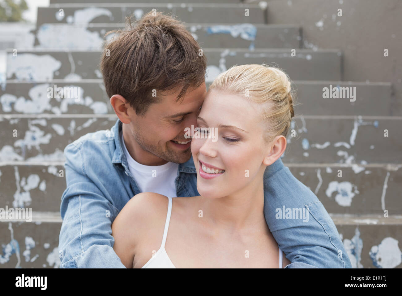 Hip young couple sitting on steps montrer de l'affection Banque D'Images