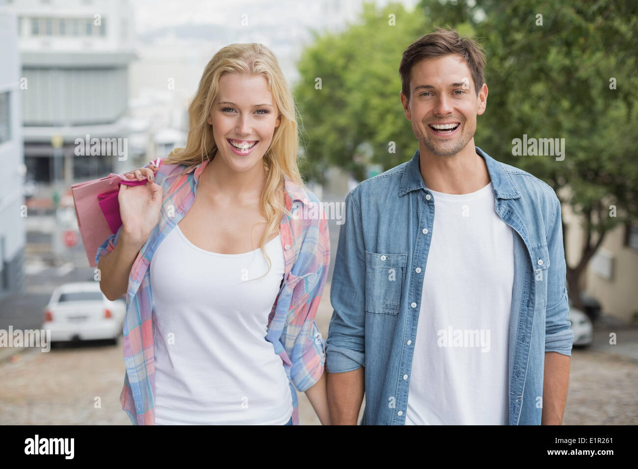 Jeune couple sur la hanche sortie shopping marche en montée Banque D'Images