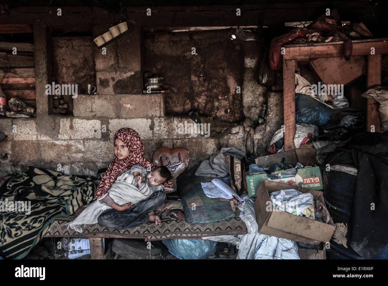 Gaza, Territoires palestiniens. 9 juin, 2014. Une fille palestinienne tient dans ses ams le frère. La famille Abu Regla se compose de 12 personnes, la famille est un des nombreux à Gaza qui vivent dans des tentes. Ils n'ont aucune source de revenu, selon les rapports des organisations des droits de l'homme que plus de 70  % de la population de Gaza vivent en dessous du seuil de pauvreté, défini par les normes internationales. © Majdi Fathi/NurPhoto ZUMAPRESS.com/Alamy/Live News Banque D'Images
