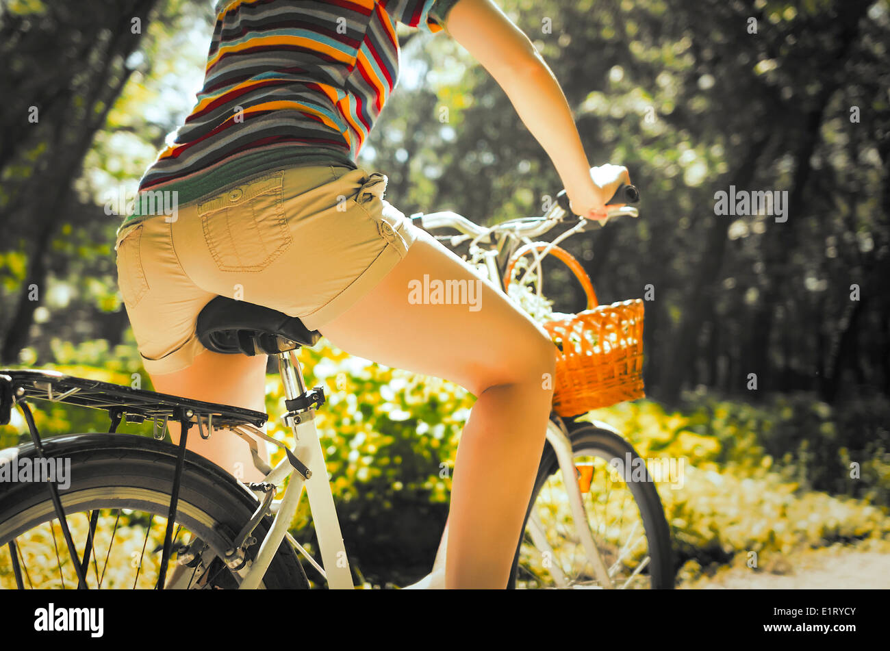 Pieds d'une belle femme sur un vélo Banque D'Images