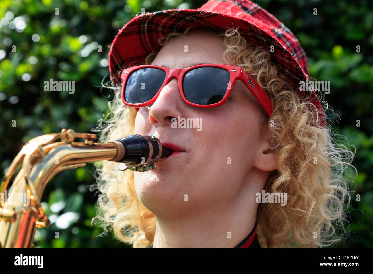 Femme portant un tartan Hat et Red Ray Ban lunettes jouer du saxophone à l'extrémité ouest Street Festival, Glasgow, Écosse, Royaume-Uni Banque D'Images