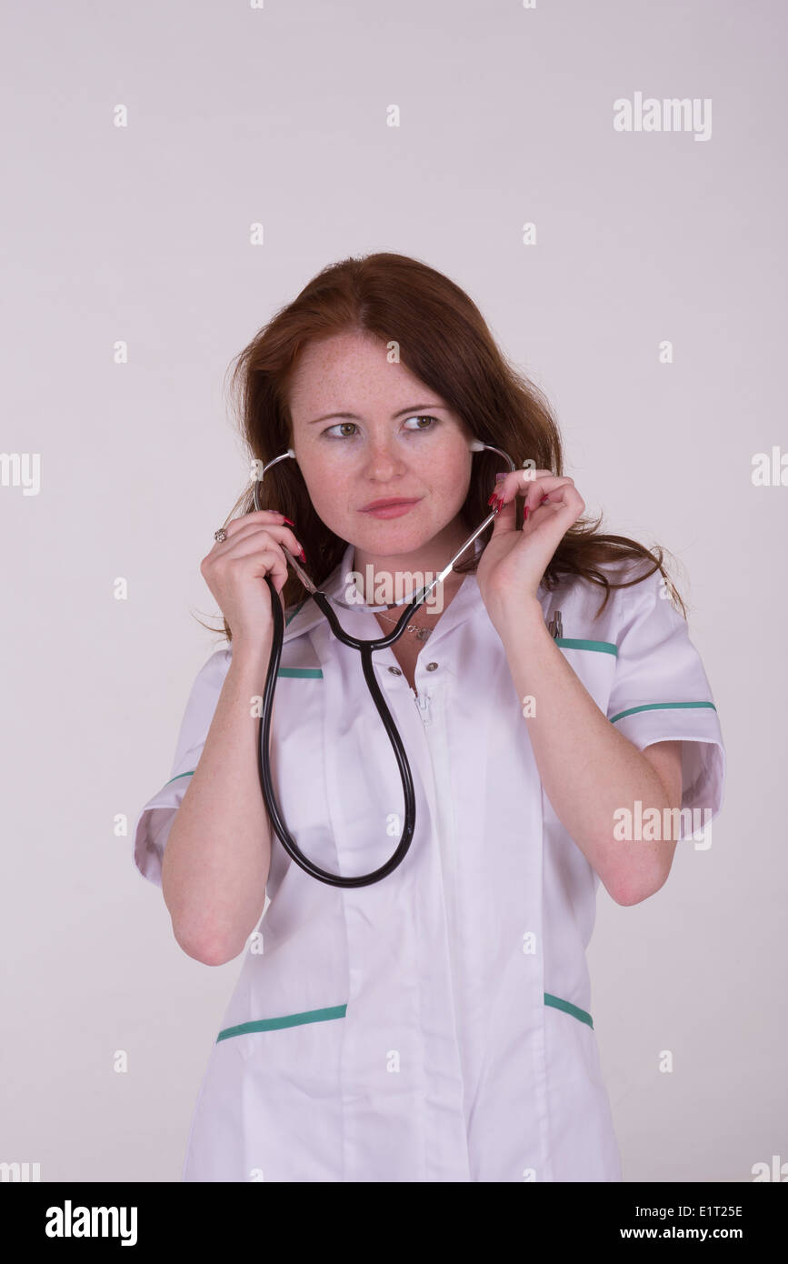 Femme médecin portant un uniforme blanc holding stethoscope Banque D'Images