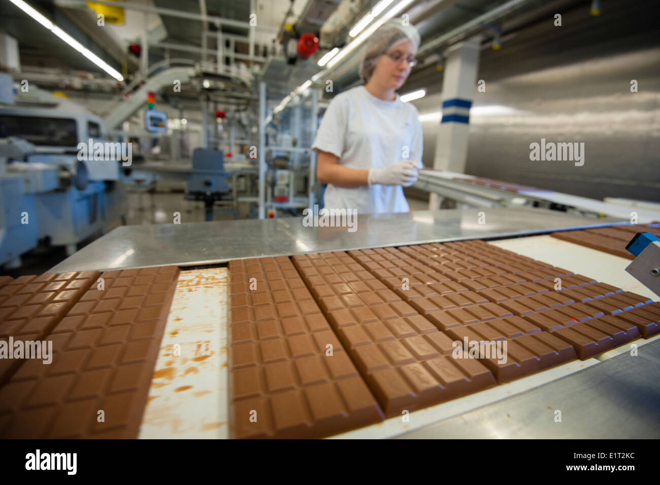 Un travailleur de l'usine de chocolat suisse Lindt & Spruengli à Zurich / Kilchberg est l'inspection de la production de barres de chocolat Banque D'Images
