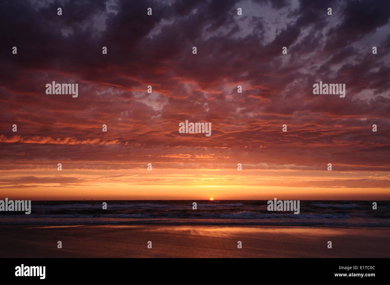 Coucher du soleil à marée haute avec la lumière du soleil et nuages ciel rouge Banque D'Images