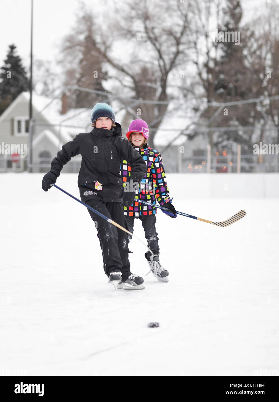 Les garçons jouer au hockey sur glace, sur une patinoire de quartier en plein air, Winnipeg, Manitoba, Canada Banque D'Images