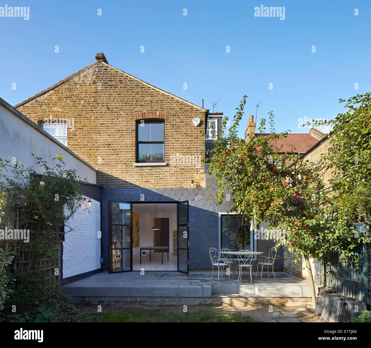 L'Ardoise House, Londres, Royaume-Uni. Architecte : Gundry & Ducker, 2013. L'élévation arrière du jardin avec terrasse et d'une nouvelle extension. Banque D'Images