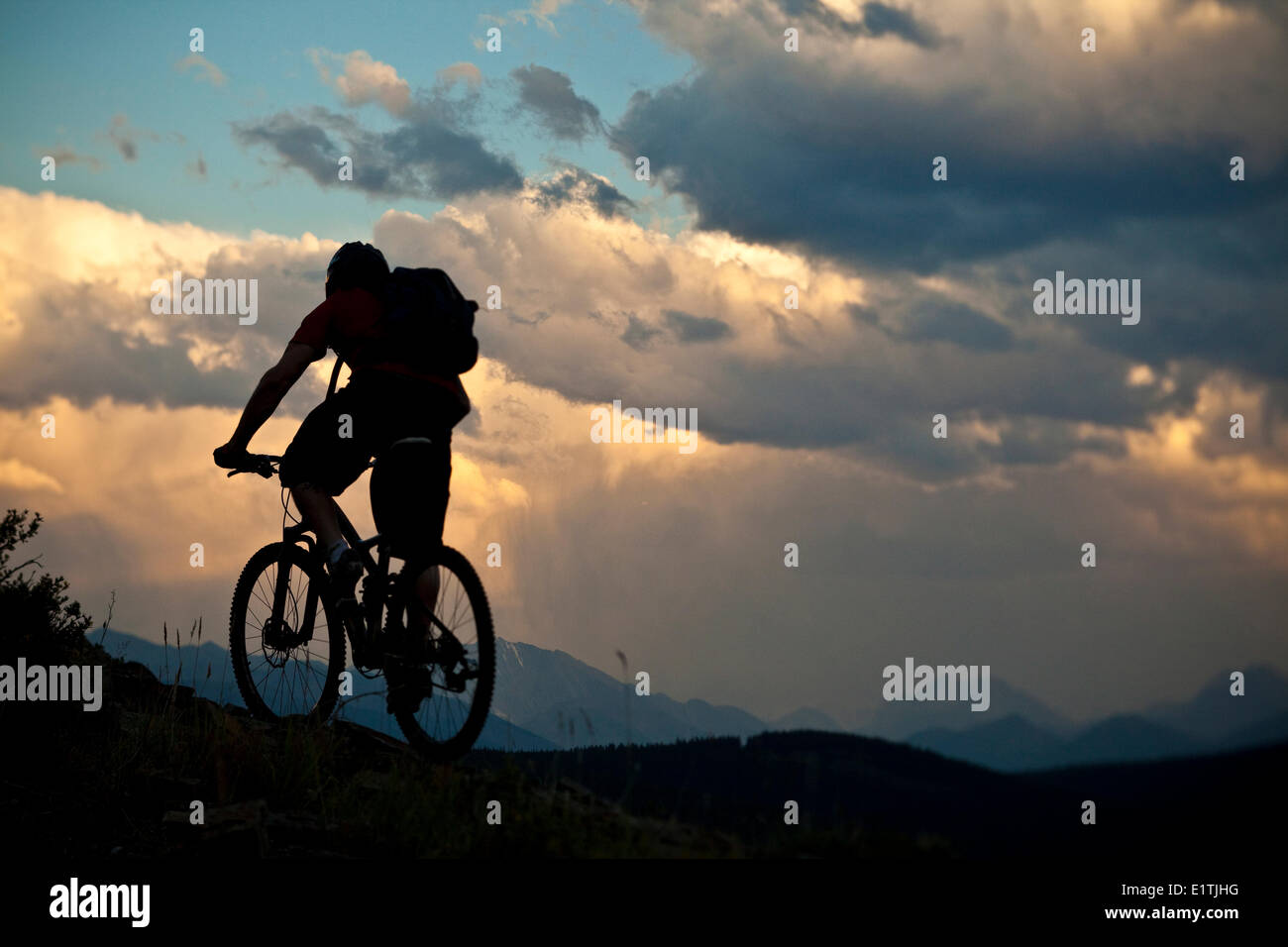 Un vélo de montagne équitation à ridgetop au coucher du soleil. Canmore, Alberta, Canada Banque D'Images