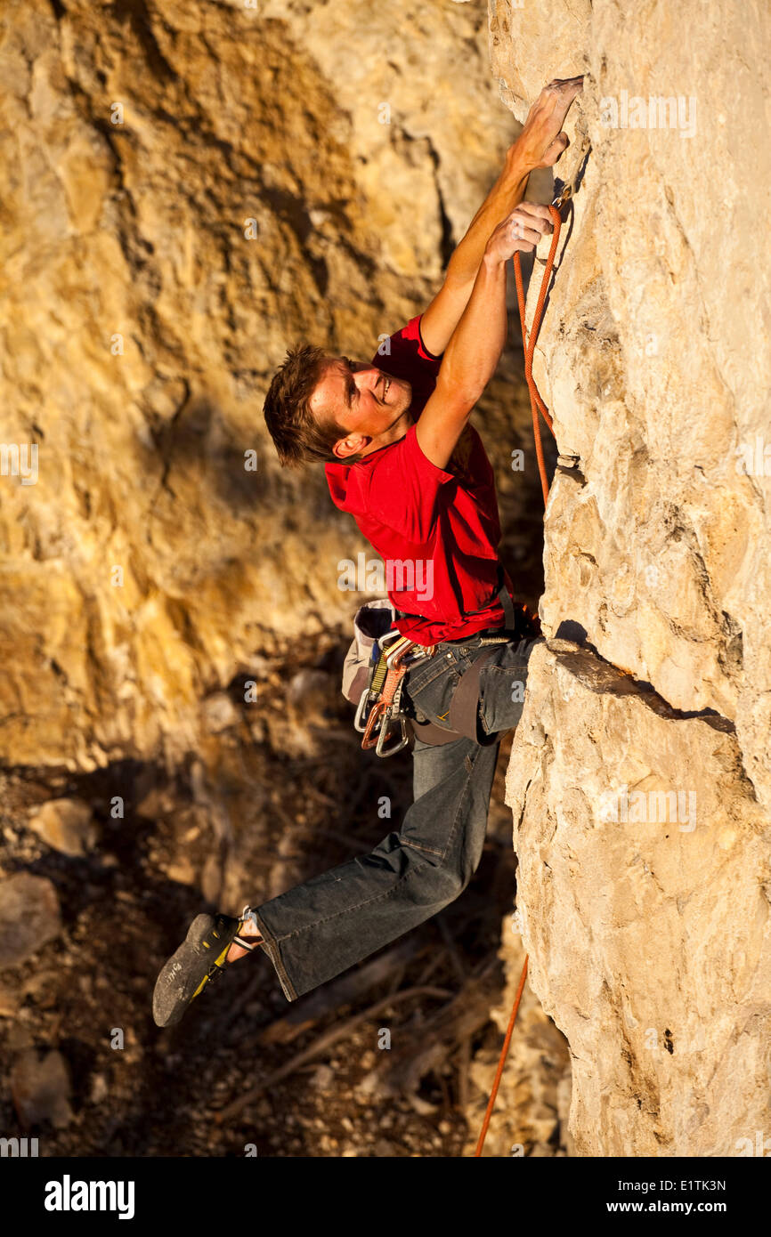 Un homme remonte la route sport Fire in the Sky 12b au coucher du soleil, Echo Canyon, Canmore, Alberta, Canada Banque D'Images